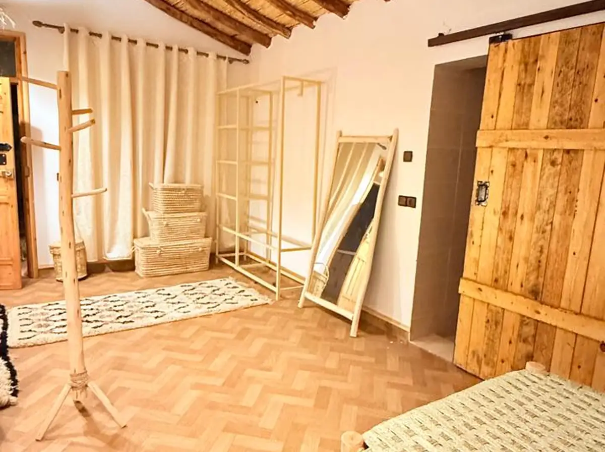 Un détail de chambre avec du linge de lit blanc.